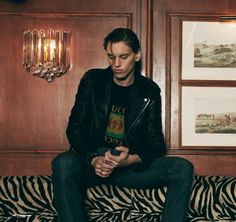 a man sitting on top of a zebra print couch