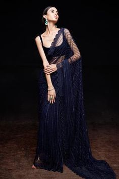 Midnight blue saree with crystal embellishments and scallop hem. Comes with velvet blouse and petticoat.
Component: 3
Pattern: Embellished
Type Of Work: Crystal
Neckline: Scoop neck
Sleeve Type: Sleeveless
Fabric: Net, Velvet
Color: Blue
Other Details: 
Crystal work
Scallop hem
Occasion: Reception, Cocktail - Aza Fashions Blue Net Saree, Sawan Gandhi, Embellished Saree, Navy Blue Saree, Crystal Work, Simple Sarees, Indian Dresses Traditional, Indian Blouse, Net Saree