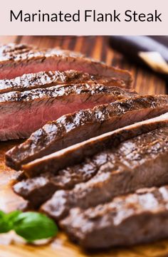 sliced flank steak on a cutting board with basil