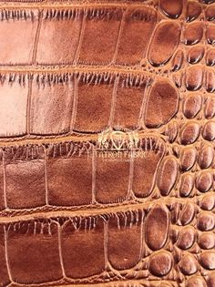 an alligator skin texture is seen in this close up photo, with the leather stitching on