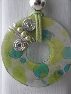 a green and white door hanger with some beads on it's front handle