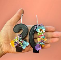 a pair of earrings with flowers on them being held by a person's hand