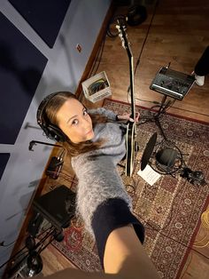 a woman with headphones on is sitting in front of a microphone and recording equipment