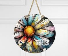 a colorful flower hanging from a door with the word hello on it's side