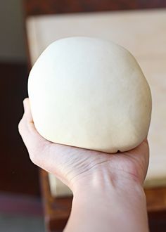 a person holding a ball of dough in their hand