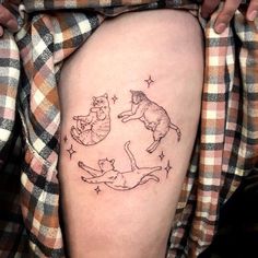 a woman's thigh with cats and stars on it