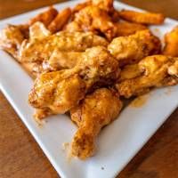 chicken wings and french fries on a white plate