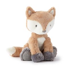 a small stuffed fox sitting on top of a white floor