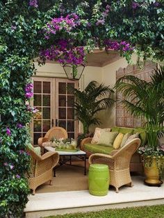 an outdoor living area with wicker furniture and potted plants