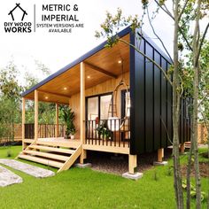 a small wooden house sitting on top of a lush green field next to a tree