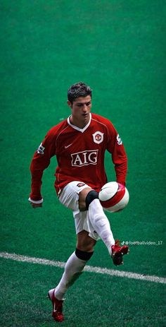 a man kicking a soccer ball on top of a field