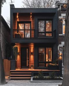 a black and brown house with lights on the windows