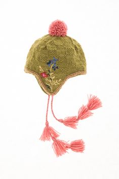 a green hat with pink tassels and flowers on it