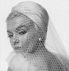 a black and white photo of a woman wearing a veil