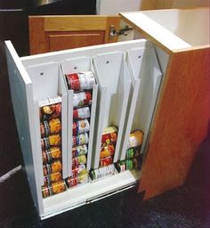 the refrigerator door is open to reveal several cans of canned food in it's compartment