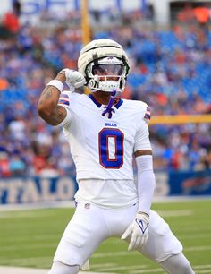 a football player is holding his hand up in the air while standing on the field