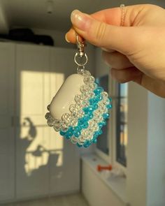 a hand holding a cup with beads hanging from it