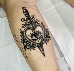 a black and white tattoo on the arm of a person with an eye in a heart