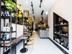 the interior of a restaurant with tables, chairs and shelves full of food on display