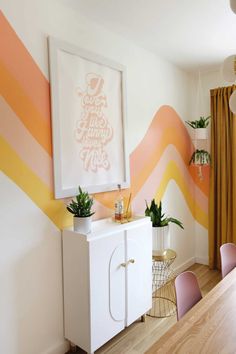 a dining room table with chairs and a painting on the wall