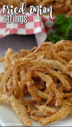 fried onion strips on a plate with dipping sauce