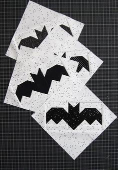 three pieces of quilted fabric with black and white bat designs on the top one is folded in half