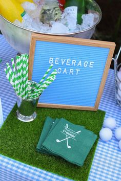 a table topped with green napkins next to a metal bucket filled with fruit and veggies