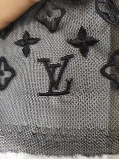 someone is stitching the letters on a piece of fabric with black thread and sequins