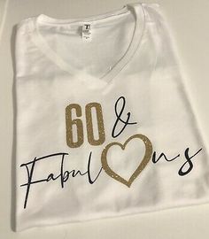 a white t - shirt with gold lettering that says 60 and fabulous on the chest