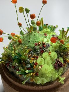 a close up of a potted plant with flowers and plants growing out of it