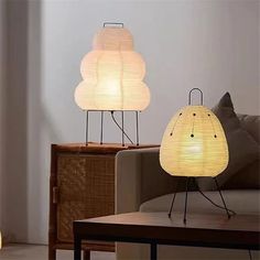 two lamps sitting on top of a table next to a couch