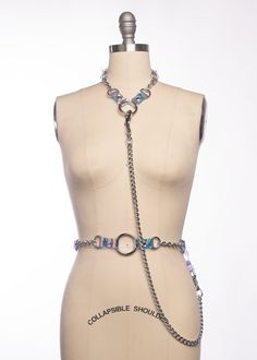 Industrial Draped Chain Harness Set includes a collar, a waist belt, and a detachable draped chain. The chain has a swivel clip on one end, and a PVC loop on the other. PVC loop snaps on/off with a heavy-duty metal snap. This is the holographic version! PVC and metal hardware are paired together, showcasing it in a way that allows it to stand out and be the main event. Buckles at neck and waist. Chains and o-rings are linked together with either iridescent blue-shift PVC. Because of the oversize Tomorrowland Outfit, Chain Harness, Harness Belt, Cool Gear, Body Jewelry Piercing, Leather Harness, Leather Chokers, Modest Outfits, Waist Belt