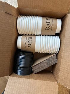 three black and white cups are in a cardboard box with brown tags on them that say bar b q