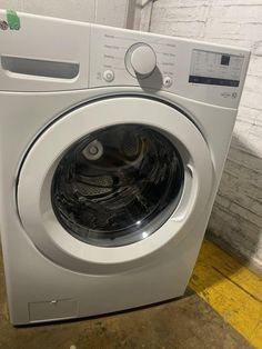 a white washing machine sitting inside of a room