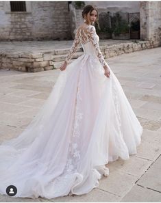 a woman in a wedding dress standing outside