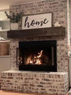 a brick fireplace with a sign above it that says home on the mantle and fire