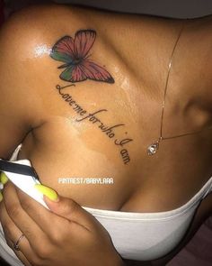 a woman with a butterfly tattoo on her chest holding a pair of scissors in her hand