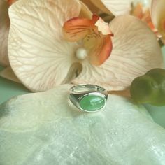 This timeless jade ring features an 18K white gold setting that encases a stunning, highly translucent jadeite cabochon in a sleek bezel arrangement. The centerpiece is a Type A jade cabochon displaying a vibrant apple green.  The remarkable translucency of the jadeite material beautifully complements the subtle pastel hue, enhancing the ring's classic design with an aura of refinement, attributed to the exceptional quality of the jade focal point. Crafted with slightly thicker bezels, the 18K g Modern Green Oval Rings, Modern Cabochon Emerald Ring For Formal Occasions, Modern Formal Emerald Cabochon Ring, Modern Oval Green Jewelry, Modern Oval Jade Jewelry, Modern Green Oval Cabochon Jewelry, Modern Jade Cabochon Jewelry, Modern Round Cabochon Emerald Ring, Modern Oval Jade Ring