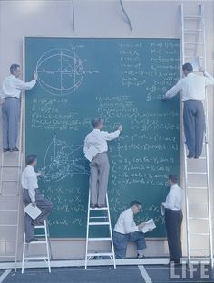 several men standing on ladders writing on a blackboard