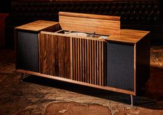 a wooden cabinet with two speakers on it