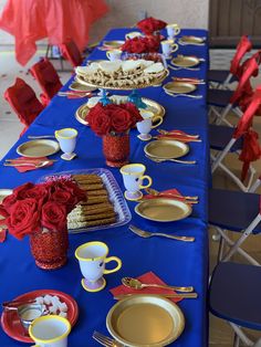 a table set with red roses and gold plates