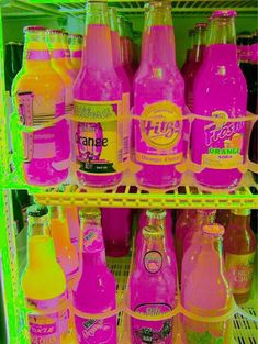 many different types of sodas are on display in a store shelf with neon colors