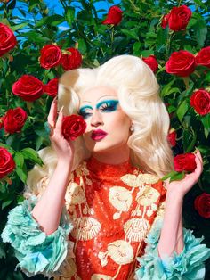 a woman with blue makeup holding roses in front of her face