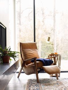 a brown leather chair sitting on top of a rug