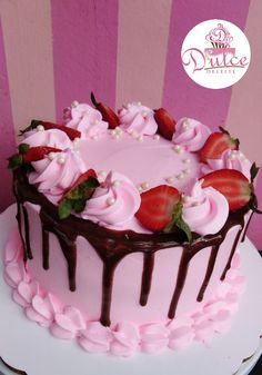 a pink cake with chocolate icing and strawberries on top