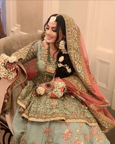 a woman sitting on top of a couch in a wedding dress