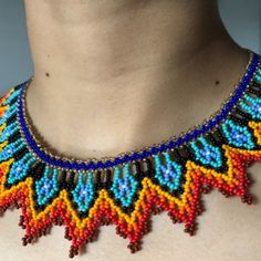 a woman wearing a multicolored beaded necklace on top of her chest,