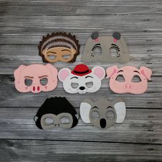 five masks with different animals on them sitting next to each other in front of a wooden background