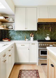 a kitchen with white cabinets and wood floors