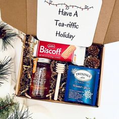 a box filled with different types of holiday treats next to pine cones and christmas decorations